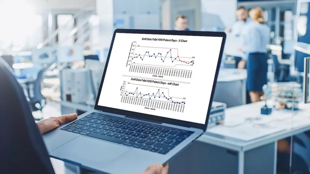 A person holding a laptop showing charts in an office, symbolizing upgrading an old laptop for better performance.